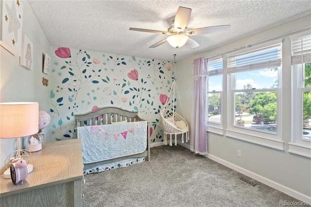 unfurnished bedroom with ceiling fan, carpet floors, and a textured ceiling