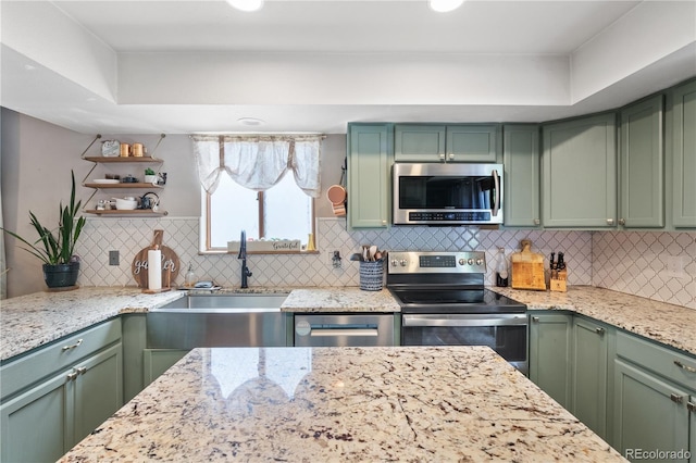 kitchen with green cabinetry, stainless steel appliances, and sink