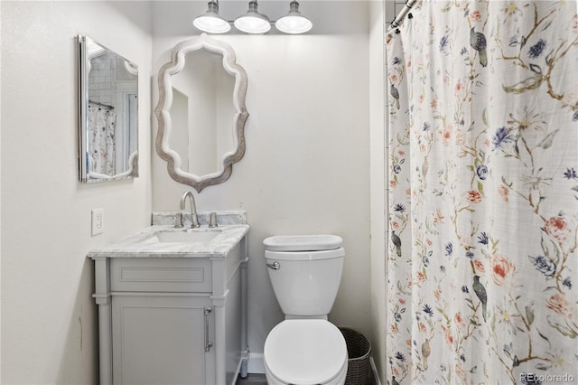 bathroom with vanity, curtained shower, and toilet