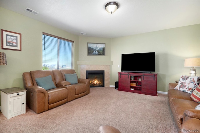 carpeted living room featuring a tiled fireplace