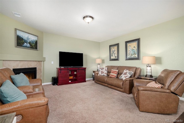 carpeted living room featuring a tiled fireplace