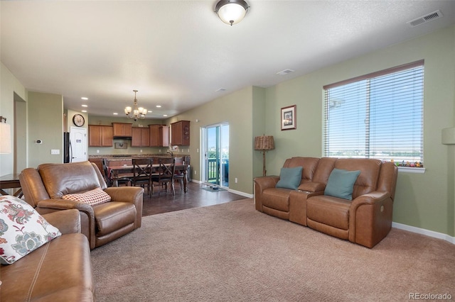 living area featuring baseboards, visible vents, recessed lighting, dark colored carpet, and a chandelier