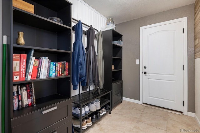 mudroom featuring light tile patterned floors and baseboards