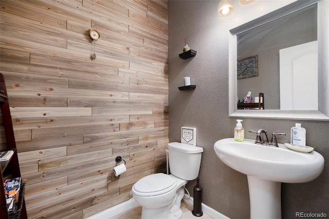 bathroom with toilet and wooden walls