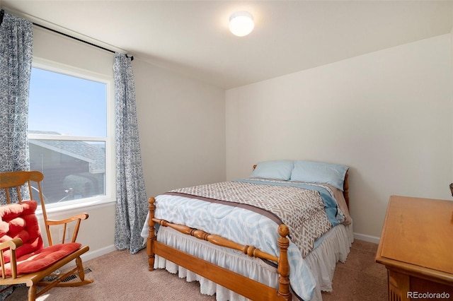 bedroom with baseboards and light colored carpet