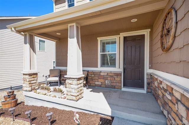 property entrance featuring a porch and stone siding