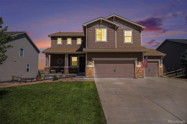 craftsman inspired home featuring concrete driveway, a lawn, board and batten siding, and stone siding