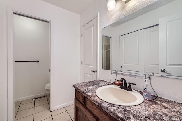 full bathroom featuring vanity, tile patterned flooring, toilet, and baseboards