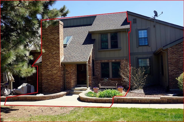7920 E Phillips Cir, Centennial, CO 80112 - tudor-style house featuring a shingled roof, board and batten siding, a chimney, and brick siding