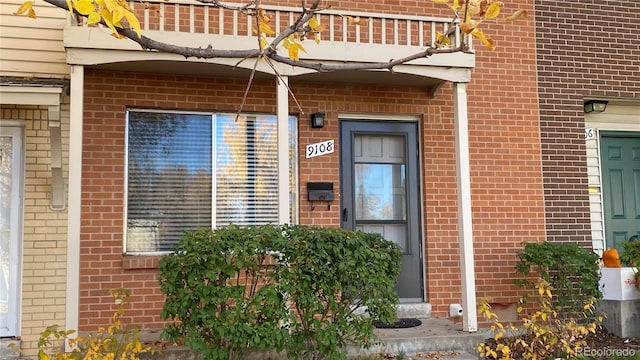 view of exterior entry with brick siding