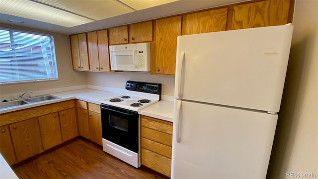 kitchen with white appliances, dark wood-style flooring, a sink, light countertops, and brown cabinets