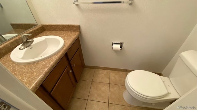 bathroom with tile patterned flooring, toilet, vanity, and baseboards