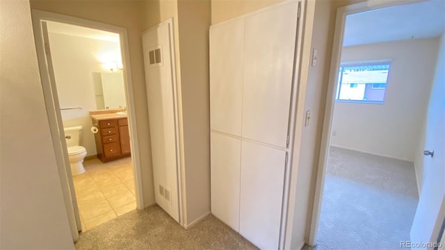 corridor featuring light tile patterned floors and visible vents