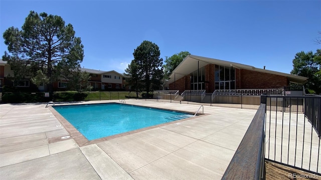 community pool featuring a patio and fence