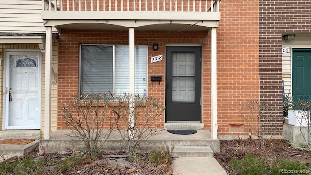 view of exterior entry with brick siding