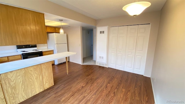 kitchen with dark wood finished floors, electric range, freestanding refrigerator, light countertops, and pendant lighting