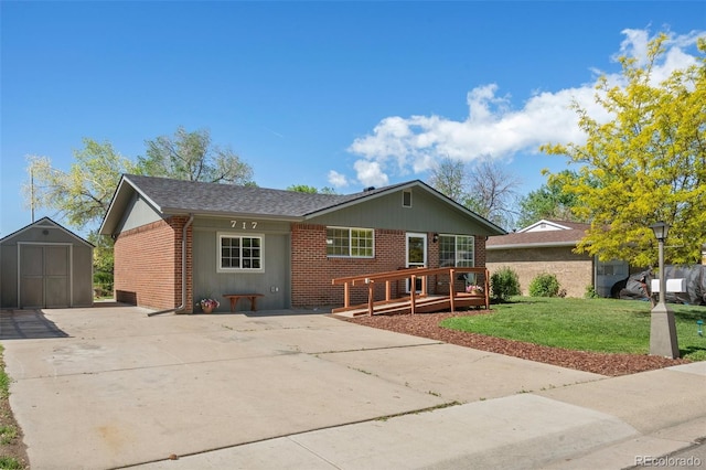 view of front of home featuring brick siding, a storage shed, a wooden deck, an outdoor structure, and a front lawn