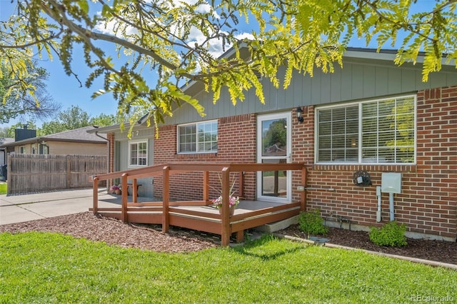 back of house with brick siding and a deck