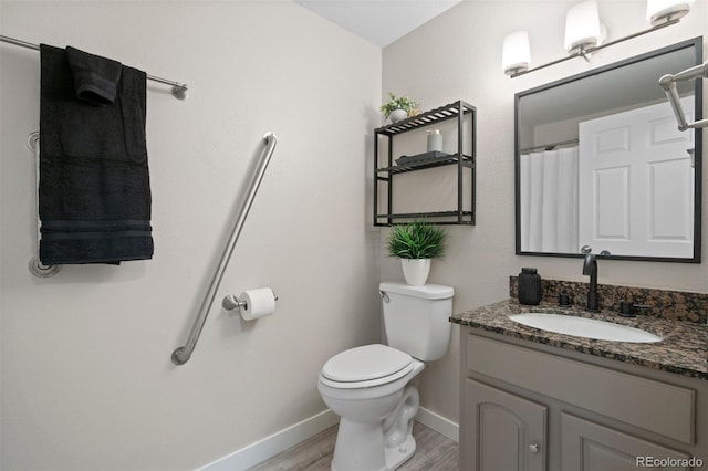 full bathroom with baseboards, wood finished floors, toilet, and vanity