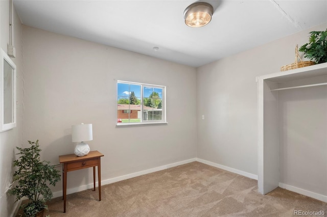 unfurnished bedroom featuring light carpet and baseboards