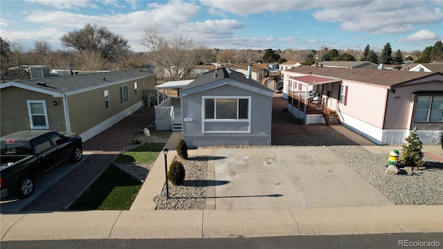 view of front of house with a wooden deck, a residential view, and central AC unit