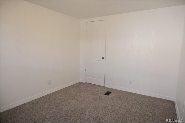empty room featuring carpet floors, visible vents, and baseboards