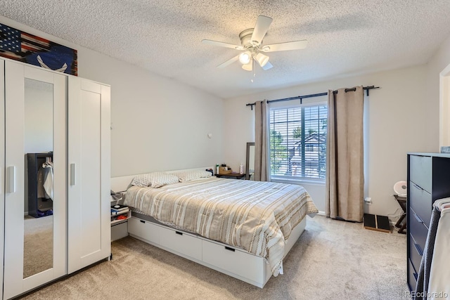 carpeted bedroom with ceiling fan and a textured ceiling