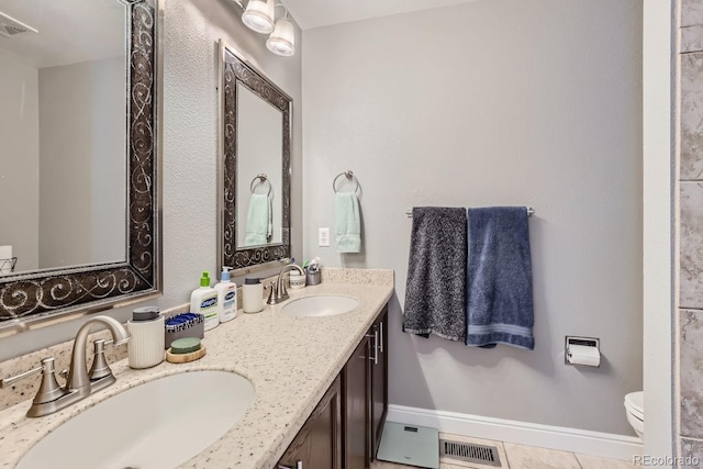 bathroom with vanity, tile patterned floors, and toilet