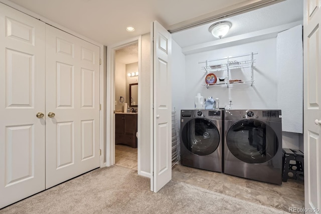 clothes washing area featuring light colored carpet and washer and dryer