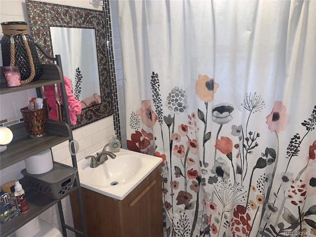 bathroom with walk in shower, vanity, and backsplash