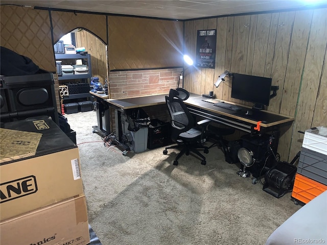 carpeted office space featuring wood walls