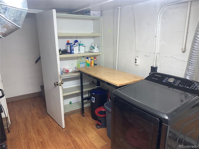 clothes washing area with hardwood / wood-style floors and washer / clothes dryer