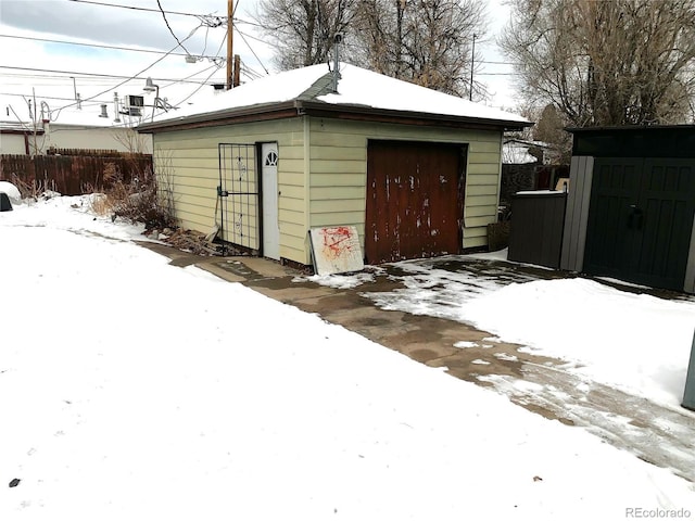 snow covered structure with a garage