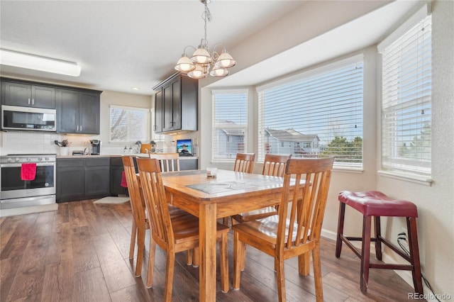 dining space with dark hardwood / wood-style flooring and a chandelier