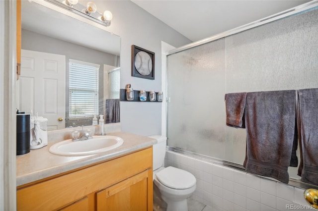 full bathroom with vanity, toilet, and enclosed tub / shower combo