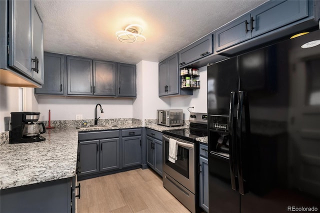 kitchen with a textured ceiling, a sink, black fridge with ice dispenser, stainless steel electric range, and light wood finished floors