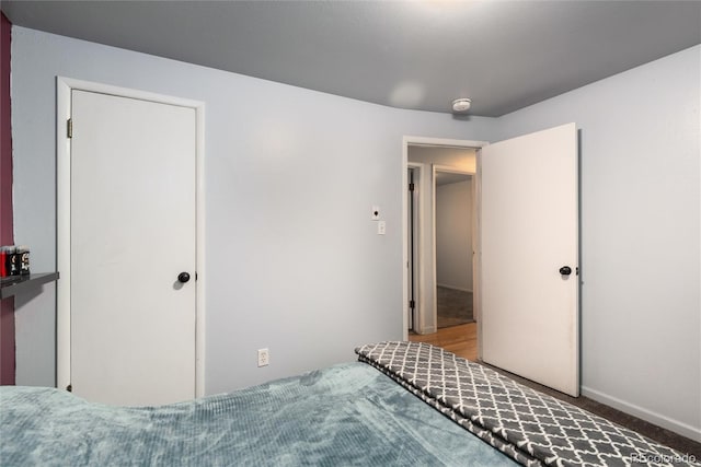 bedroom featuring carpet and baseboards