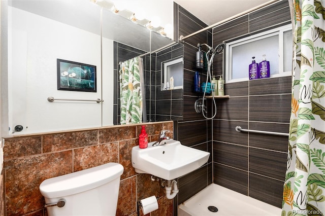 bathroom featuring toilet, a sink, a tile shower, and tile walls