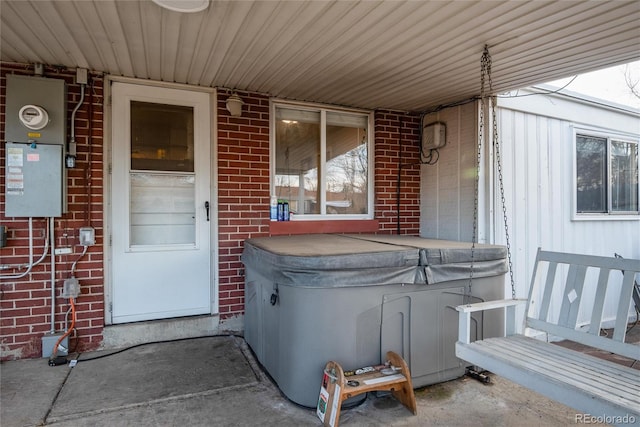 property entrance featuring brick siding and a hot tub