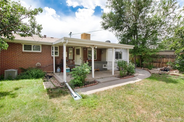 6903 W 52nd Pl, Arvada, CO 80002 - view of front of house featuring a chimney, brick siding, and a patio