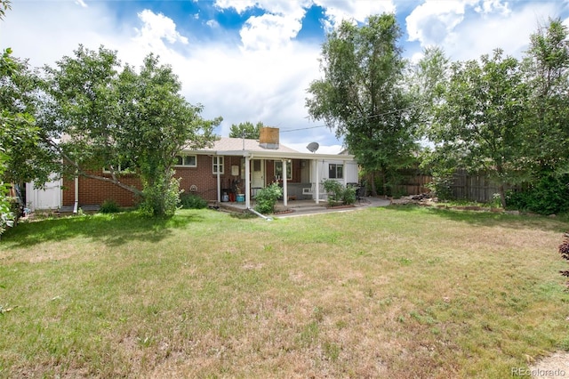 6903 W 52nd Pl, Arvada, CO 80002 - back of property featuring a patio area, brick siding, and a chimney