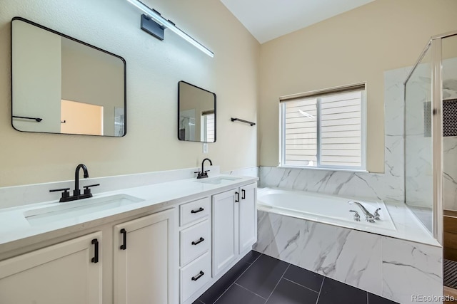 bathroom featuring a marble finish shower, double vanity, a sink, and a bath