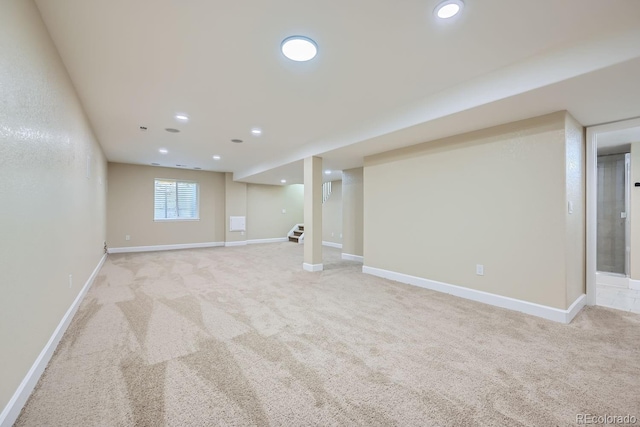 basement with recessed lighting, light carpet, baseboards, and stairs