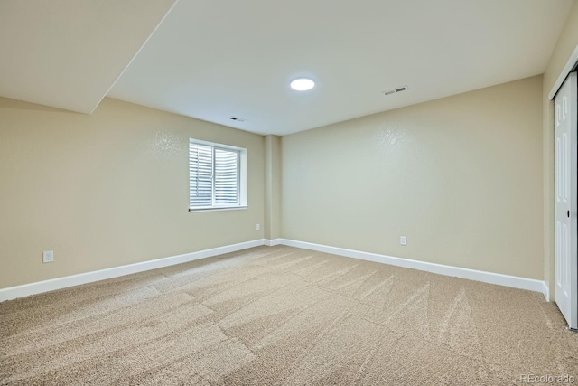 carpeted spare room featuring visible vents and baseboards