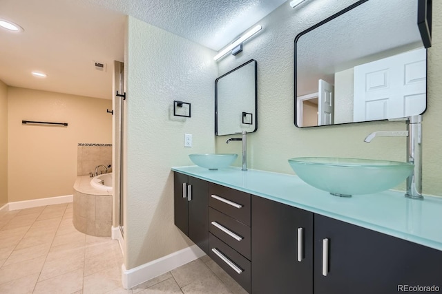 bathroom with a bath, tile patterned flooring, double vanity, and a sink