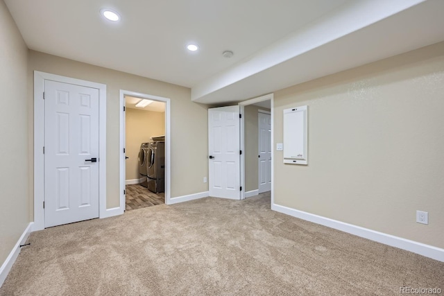 interior space with light carpet, baseboards, independent washer and dryer, a walk in closet, and recessed lighting