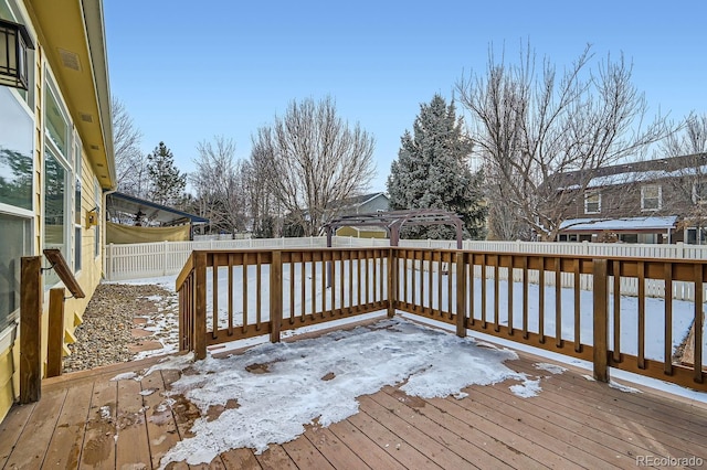 snow covered deck featuring a fenced backyard and a pergola