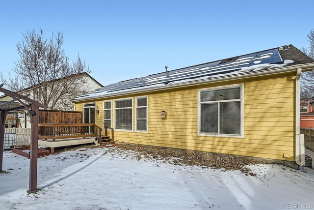 snow covered house with a wooden deck