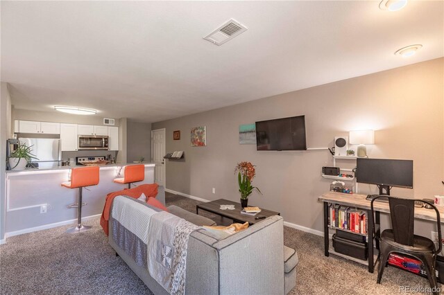 living room with visible vents, baseboards, and light carpet