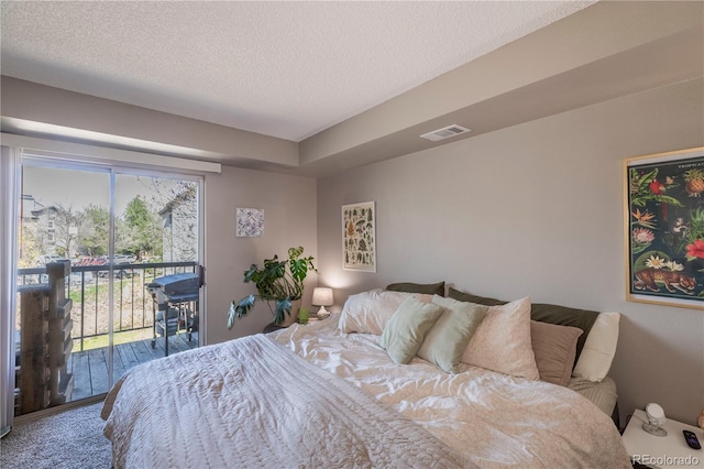 bedroom with access to outside, a textured ceiling, and visible vents